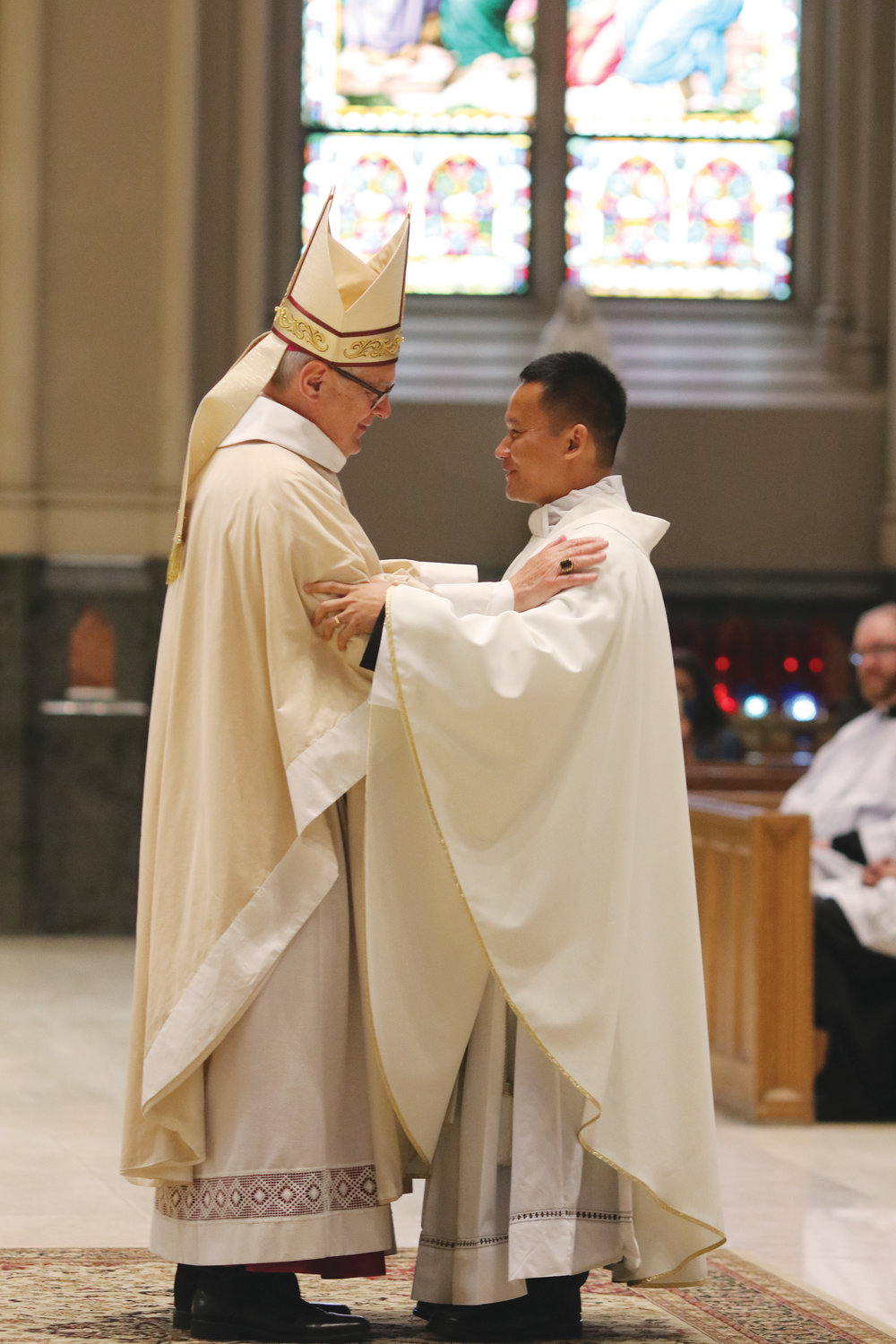 Bishop Thomas J. Tobin congratulates Father Nguyen.